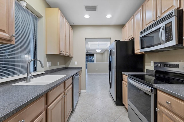 kitchen featuring light tile patterned floors, stainless steel appliances, light brown cabinetry, and sink