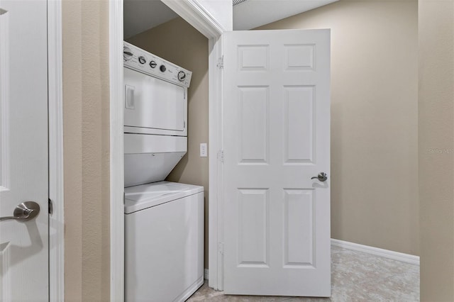 laundry area with stacked washer and clothes dryer and light tile patterned flooring