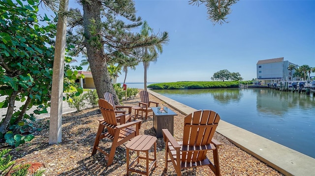 exterior space featuring a water view and a fire pit