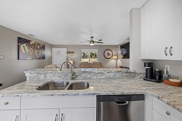 kitchen with sink, stainless steel dishwasher, white cabinetry, light stone counters, and kitchen peninsula