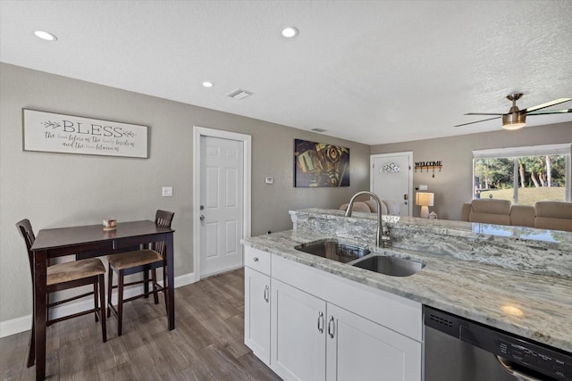 kitchen with dishwasher, sink, light stone counters, hardwood / wood-style floors, and white cabinets