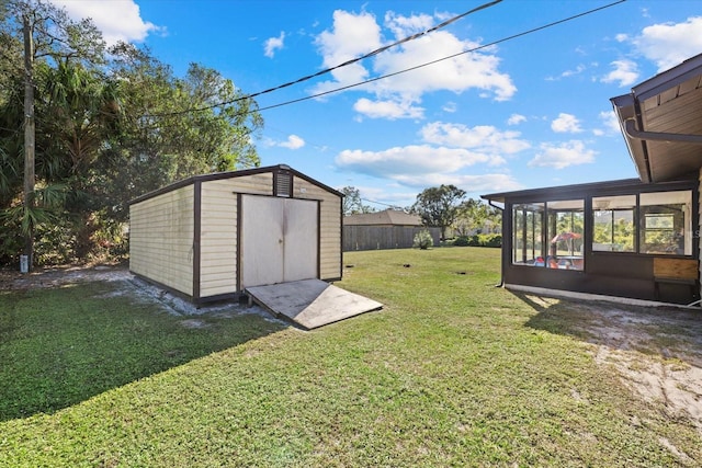 view of yard with a shed and a sunroom