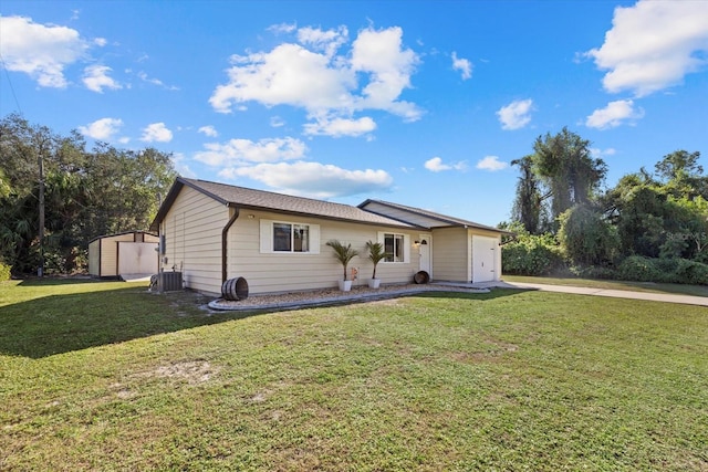 ranch-style home with a front yard, cooling unit, and a storage shed