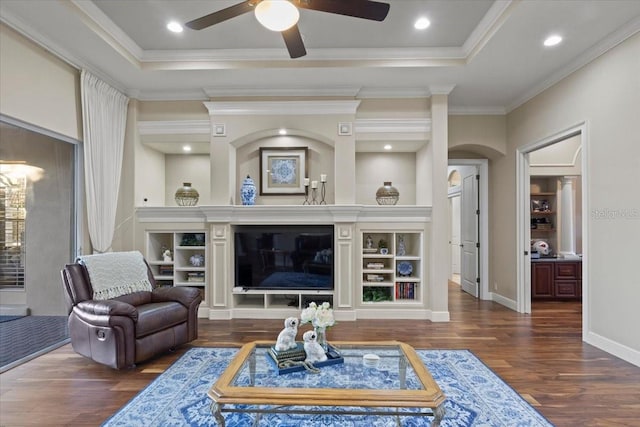 living room featuring ceiling fan, dark hardwood / wood-style flooring, crown molding, and a tray ceiling