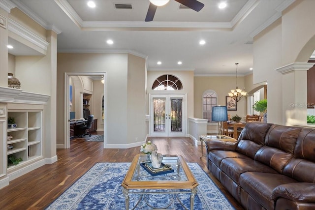 living room featuring ceiling fan with notable chandelier, french doors, dark hardwood / wood-style flooring, and ornamental molding