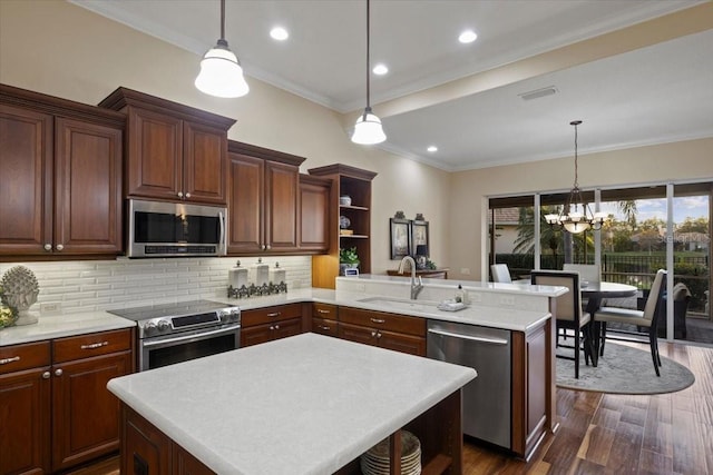 kitchen featuring kitchen peninsula, stainless steel appliances, and hanging light fixtures