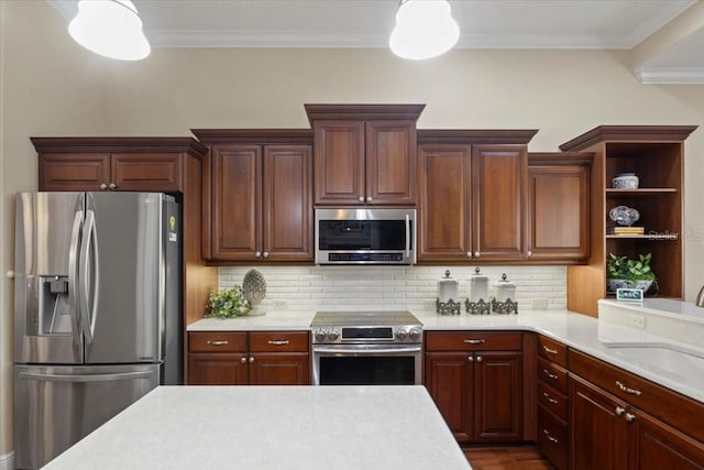 kitchen with pendant lighting, decorative backsplash, ornamental molding, and appliances with stainless steel finishes