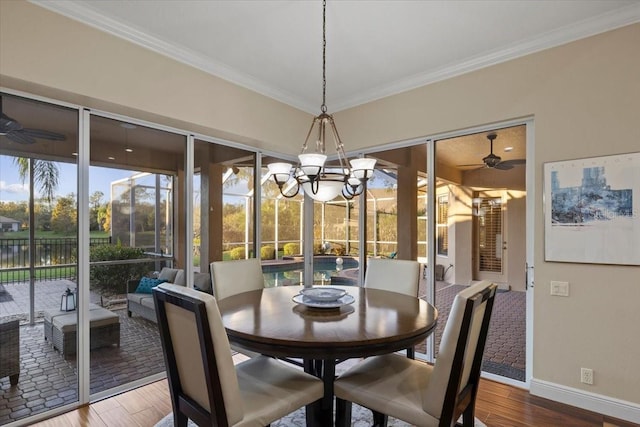 dining space featuring hardwood / wood-style floors, ceiling fan with notable chandelier, and crown molding