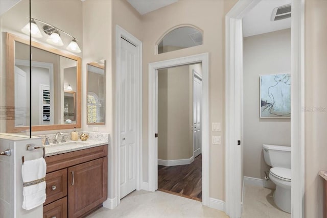 bathroom featuring hardwood / wood-style floors, vanity, and toilet