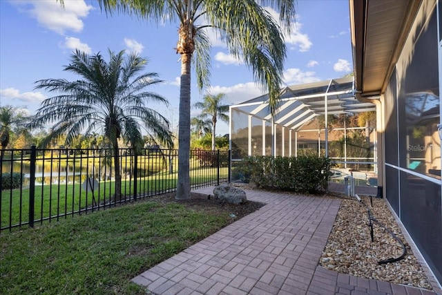 view of yard with glass enclosure and a water view