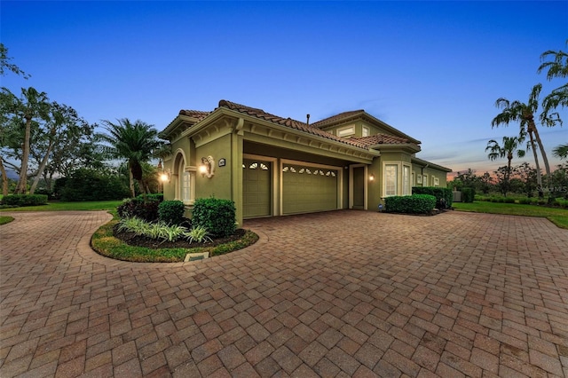 mediterranean / spanish home featuring a garage