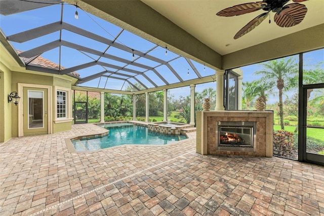 view of swimming pool featuring ceiling fan, a lanai, a patio, and exterior fireplace