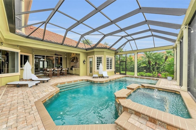 view of swimming pool featuring ceiling fan, a lanai, pool water feature, an in ground hot tub, and a patio