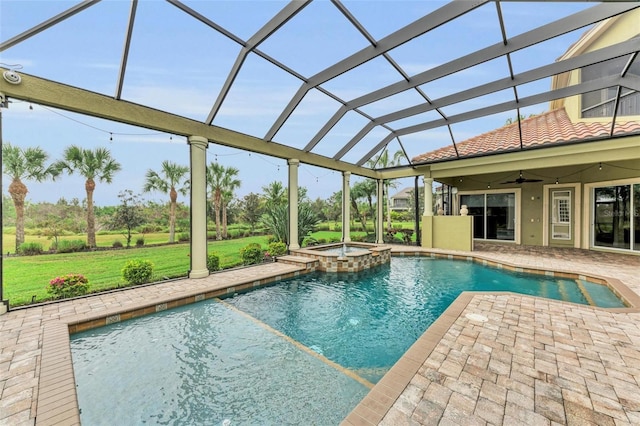 view of pool featuring an in ground hot tub, a lanai, ceiling fan, a patio area, and a yard