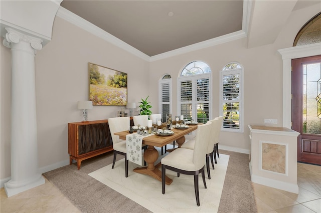 tiled dining room featuring decorative columns and crown molding