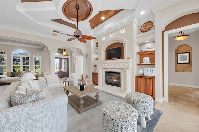 living room with ornate columns, ceiling fan, coffered ceiling, a fireplace, and ornamental molding