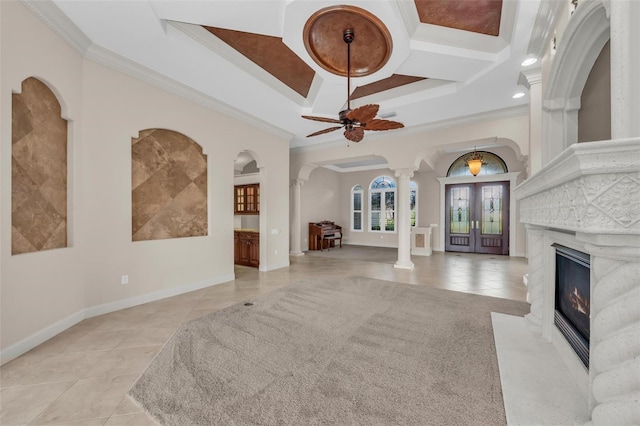 tiled living room featuring coffered ceiling, french doors, ceiling fan, ornamental molding, and ornate columns