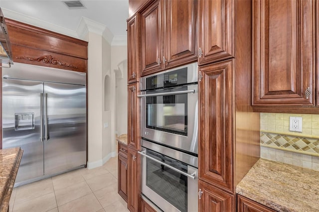 kitchen with stainless steel appliances, light stone counters, tasteful backsplash, and ornamental molding