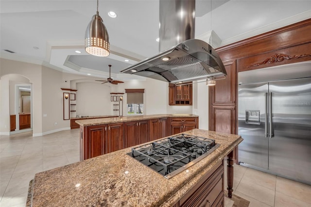 kitchen featuring a center island, gas cooktop, built in fridge, decorative light fixtures, and island range hood