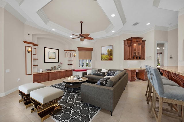 tiled living room featuring a tray ceiling, ceiling fan, and ornamental molding