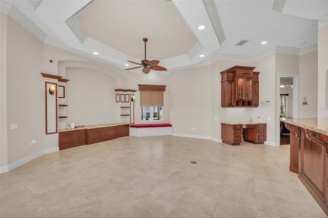 unfurnished living room with ceiling fan, ornamental molding, and a tray ceiling