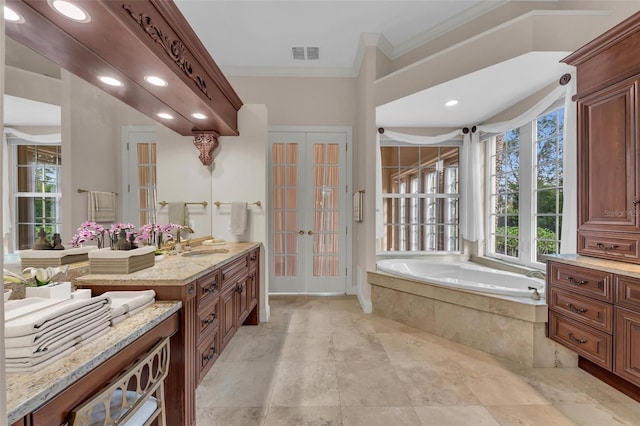 bathroom with french doors, vanity, ornamental molding, and tiled tub