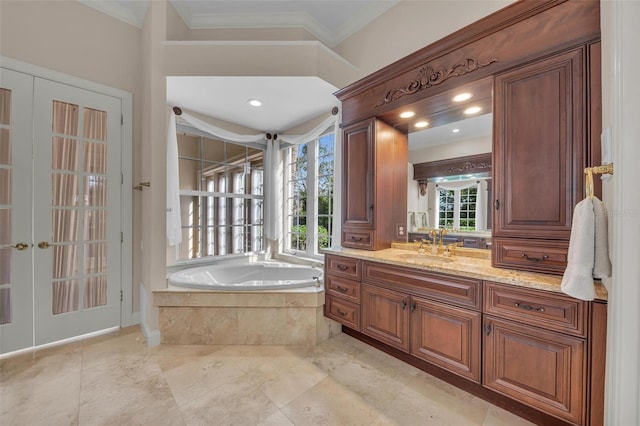 bathroom featuring tiled bath, crown molding, french doors, and vanity