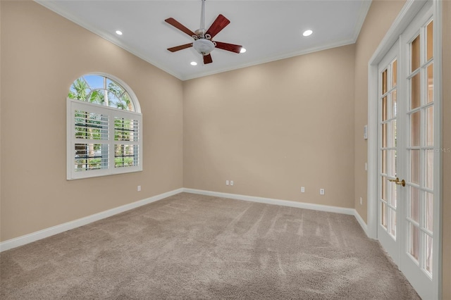 carpeted spare room with crown molding, french doors, and ceiling fan