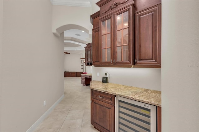 bar featuring light stone counters, light tile patterned floors, crown molding, and beverage cooler