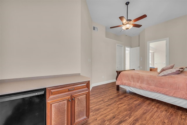 bedroom featuring dark hardwood / wood-style flooring, wine cooler, ceiling fan, and connected bathroom