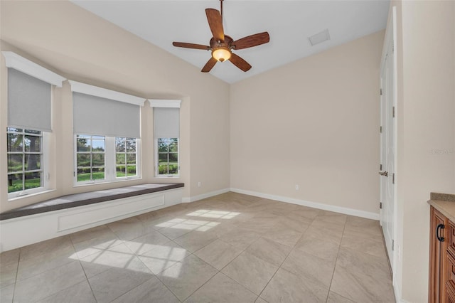 tiled empty room featuring ceiling fan and vaulted ceiling