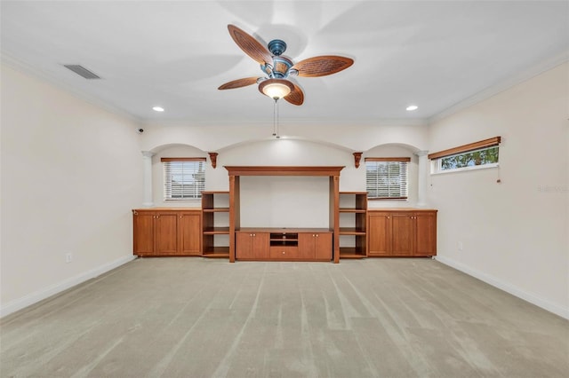 unfurnished living room featuring a healthy amount of sunlight, light colored carpet, ceiling fan, and ornamental molding