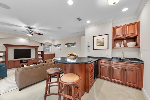 kitchen with crown molding, a breakfast bar, light colored carpet, and sink