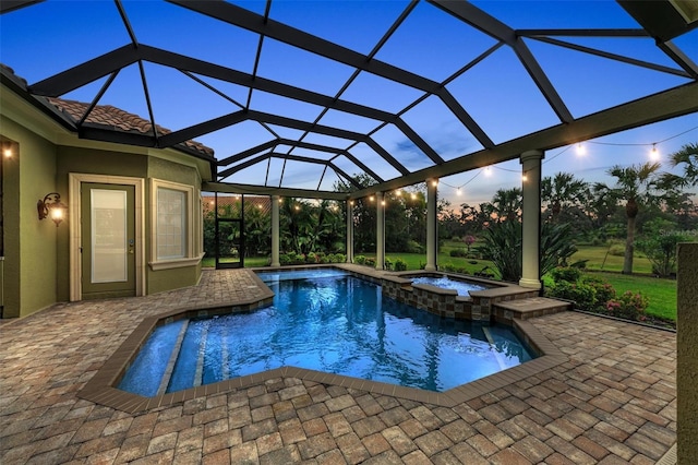 view of swimming pool with glass enclosure, an in ground hot tub, and a patio area