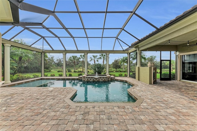 view of swimming pool with glass enclosure, an in ground hot tub, and a patio area