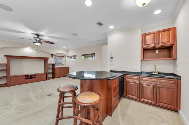 kitchen featuring a kitchen breakfast bar, crown molding, light carpet, sink, and kitchen peninsula