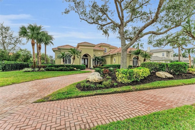 mediterranean / spanish home with a front lawn