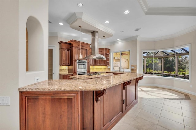 kitchen with kitchen peninsula, decorative light fixtures, island range hood, crown molding, and a breakfast bar area