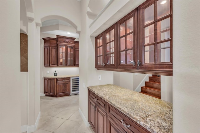 bar with light tile patterned flooring, light stone countertops, and beverage cooler