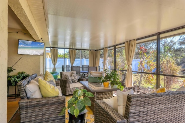 sunroom featuring beam ceiling