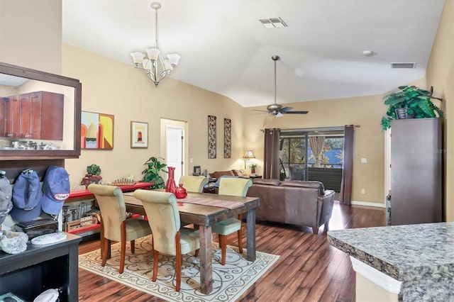 dining space with ceiling fan with notable chandelier, dark wood-type flooring, and vaulted ceiling