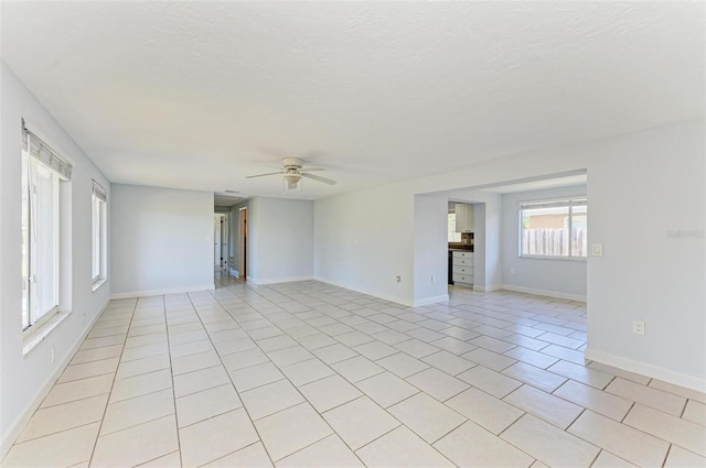 tiled spare room with ceiling fan and a textured ceiling