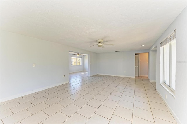 unfurnished room featuring ceiling fan, plenty of natural light, and light tile patterned flooring