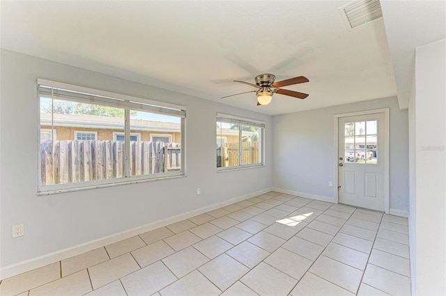 tiled spare room with a wealth of natural light and ceiling fan