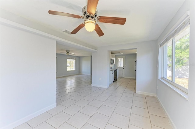 tiled empty room featuring ceiling fan