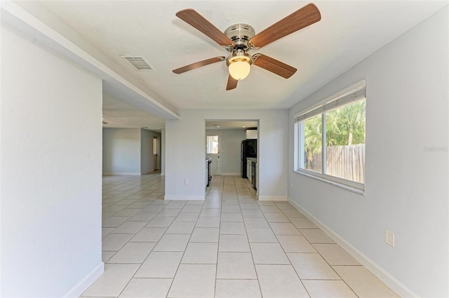 empty room with ceiling fan and light tile patterned floors