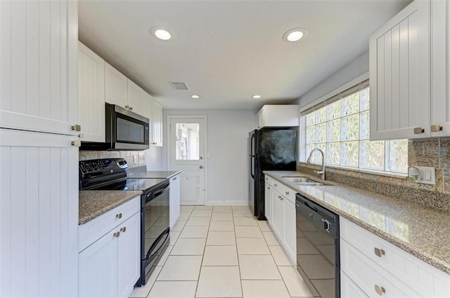 kitchen with light stone countertops, decorative backsplash, white cabinetry, and black appliances