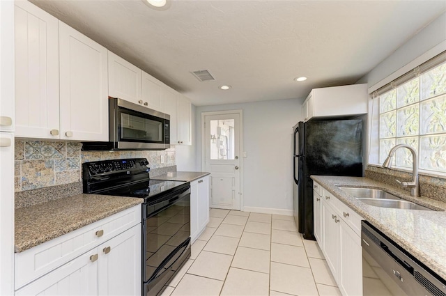 kitchen with light stone countertops, decorative backsplash, sink, black appliances, and white cabinetry