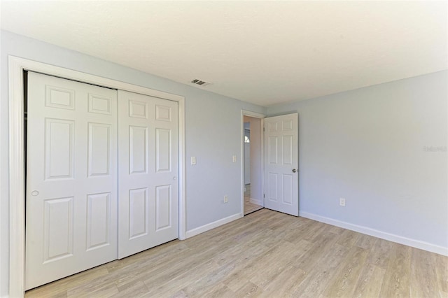 unfurnished bedroom featuring light wood-type flooring and a closet