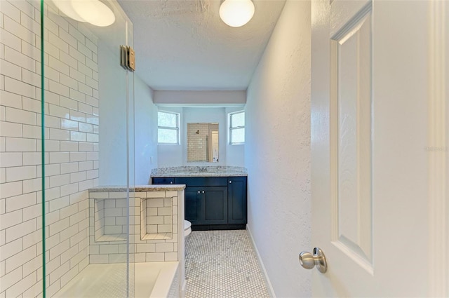 bathroom featuring a tile shower, tile patterned floors, a textured ceiling, toilet, and vanity